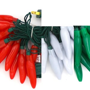 May include: A string of chili pepper shaped Christmas lights with red, white, and green bulbs. The lights are strung together with green wire.