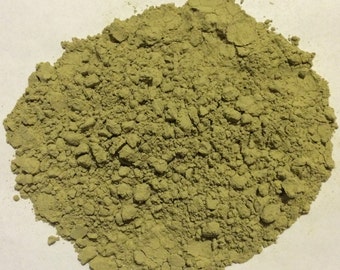 May include: A close-up view of a pile of green powder. The powder is finely ground and has a uniform texture.
