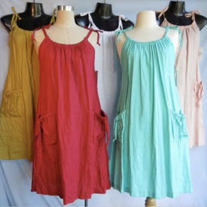 Vestido de verano holgado de lino con bolsillos, escote con cordón y tirantes ajustables, disponible en cinco colores.