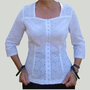 Weiße Bluse mit Broderie Anglaise, Sweetheart Ausschnitt, Haken- und Ösenverschluss und Dreiviertelärmel ist auch in reinem Leinen erhältlich.