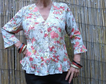 Flower print top with V neck and three quarter sleeves has Pearl Buttons and Peplum frill at hips.