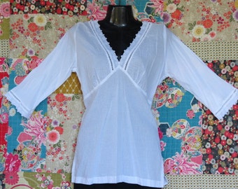 White Cotton  Summer top with Broderie Anglaise trims on V neck and three quarter sleeves is cool and feminine.