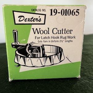 May include: A square cardboard box for a Dexter's Wool Cutter for latch hook rug work. The box is light green and white with black text and a black and white illustration of the tool. It states it cuts yarn in uniform 2 1/2 inch lengths.