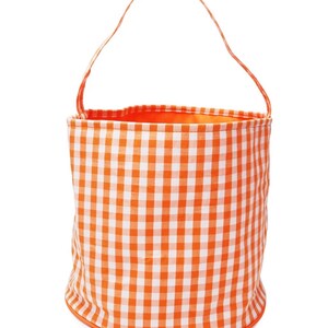 May include: Orange and white gingham fabric bucket with a handle. The bucket is made of fabric and has a gingham pattern.