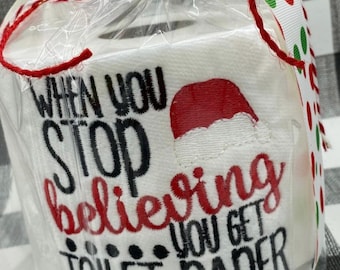 May include: A white toilet paper roll with a red and white Santa hat and the text "When you stop believing you get toilet paper" in black embroidery.
