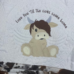 May include: White quilted baby blanket with a brown and white embroidered cow and the text "Love You 'Til The Cows Come Home".