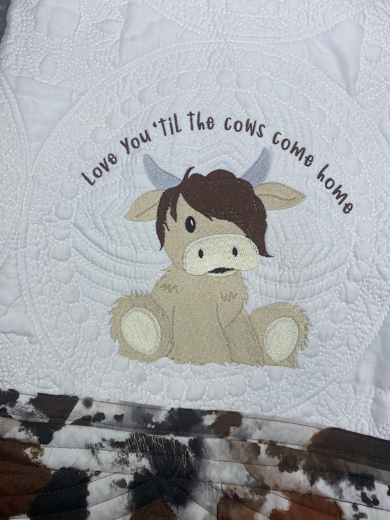 May include: White quilted baby blanket with a brown and white embroidered cow and the text "Love You 'Til The Cows Come Home".