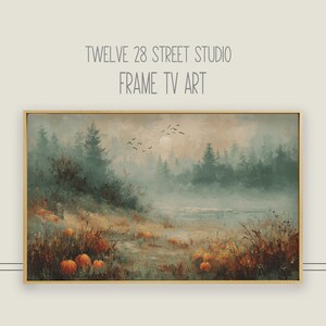 Puede incluir: Pintura de paisaje enmarcada con una serena escena otoñal. La obra presenta un bosque brumoso, una masa de agua y calabazas en primer plano. El texto "TWELVE 28 STREET STUDIO FRAME TV ART" está en la parte superior.
