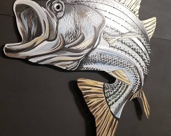 Puede incluir: Una escultura de pescado de madera pintada en plata y negro con un diseño detallado. El pez tiene una boca grande y una cola con detalles dorados.