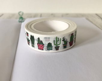 May include: A roll of white washi tape with a repeating pattern of potted cacti in various colors and styles.