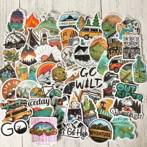May include: A collection of colourful stickers with outdoor adventure themes. The stickers feature illustrations of mountains, trees, campfires, and other nature-inspired designs. Some of the stickers have text, such as "Go Wild", "Adventure", and "Let's Get High".