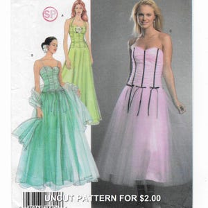 Peut inclure: Un patron de couture non coupé avec des illustrations de trois robes de soirée. Les robes sont dans des tons de vert et de rose, avec des jupes en tulle et des corsages ajustés. Le texte "UNCUT PATTERN FOR $2.00" est visible.