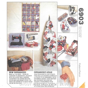 May include: A sewing-themed image featuring various fabric projects. Includes a sewing machine cover, ironing board cover, pin cushions, and a wall hanging organizer. The text reads "Sew Organized".
