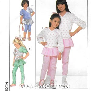 Naaipatroon voor een stretch gebreide broek met aangehechte rok en V-hals top voor kinderen: ongeknipt - Maten S-M-L (3-4-5-6-6x) • Simplicity 9272
