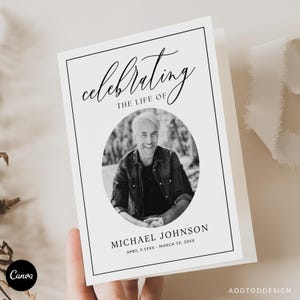 May include: A folded white memorial card with a black border. The card features the words "celebrating the life of" in elegant script above a black and white photo of a smiling man. The name "MICHAEL JOHNSON" and dates are below the photo.