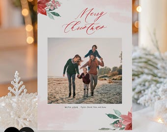 May include: A rectangular Christmas greeting card featuring a central photograph of a family of four walking on a beach. The card has red poinsettia and green leaf illustrations, the text Merry Christmas, and the text WITH LOVE Taylor, David, Tom, and Anna.