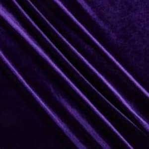 May include: Close-up of a deep purple velvet fabric. The fabric has a soft, luxurious texture with visible diagonal folds and subtle variations in color, creating a rich, elegant appearance. The lighting highlights the sheen of the material.