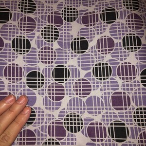 May include: Purple and black patterned fabric with a geometric design of overlapping circles and a grid pattern.