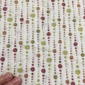 May include: White fabric with a repeating pattern of vertical lines of small green, brown, and burgundy circles.
