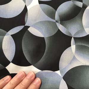 May include: Abstract fabric with a black background and overlapping circles in shades of gray and white.
