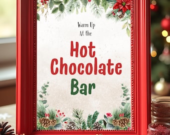 May include: A framed sign with the words "Warm Up At the Hot Chocolate Bar" in red and green. The red frame surrounds a cream-colored background with festive greenery and pinecones. The sign is on a wooden surface with decorative elements.