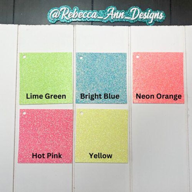 May include: Five square samples of glitter paper in different colors: lime green, bright blue, neon orange, hot pink, and yellow.