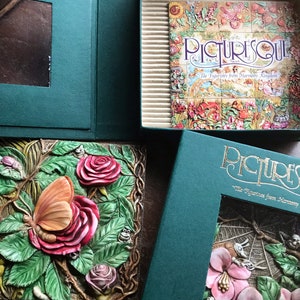 Może przedstawiać: Zestaw dekoracyjnych płytek ceramicznych z kwiatowym wzorem z motylami i żabami. Płytki są częścią kolekcji o nazwie "Picturesque: Tile Figurines from Harmony Kingdom".