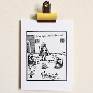 May include: A black and white cartoon print of a historical figure, Matthew Hopkins, with sandwich options. The print includes text bubbles with sandwich ingredients and names, such as "Ham" and "BLT". The print is held by a yellow clip.