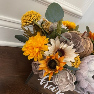 Peut inclure: Une bo&icirc;te en bois avec le mot "harvest" &eacute;crit dessus. La bo&icirc;te est remplie d'une vari&eacute;t&eacute; de fleurs d'automne, dont des tournesols, des chrysanth&egrave;mes et de l'eucalyptus.