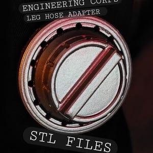 May include: A circular silver-colored Engineering Corps leg hose adapter with a central raised bar and a ring of small holes around the perimeter. The text ENGINEERING CORPS LEG HOSE ADAPTER and STL FILES is visible on the dark background.