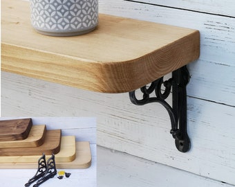 May include: A set of three wooden shelves with rounded edges and black metal brackets. The shelves are made of natural wood and have a rustic look. The shelves are perfect for displaying plants, books, or other decorative items.