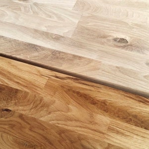 Pu&ograve; includere: Due pezzi di pavimentazione in legno, uno marrone chiaro e uno marrone scuro, che mostrano la venatura del legno.