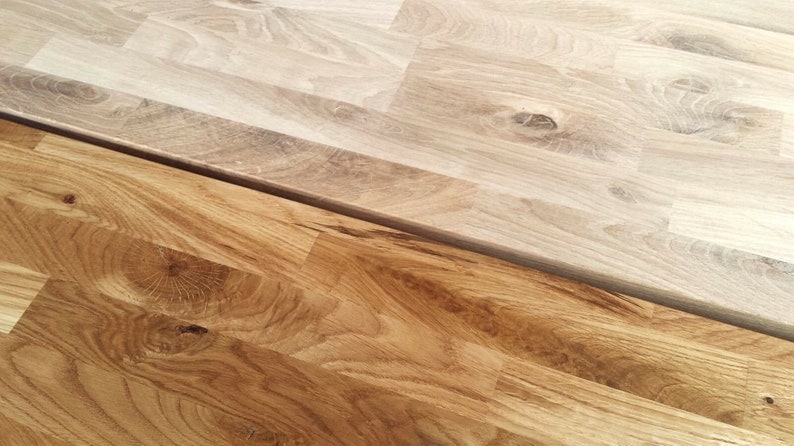 Pu&ograve; includere: Due pezzi di pavimentazione in legno, uno marrone chiaro e uno marrone scuro, che mostrano la venatura del legno.