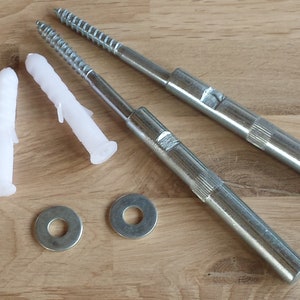 May include: Two silver metal screws with white plastic anchors and two silver metal washers. The screws are approximately 6 inches long.