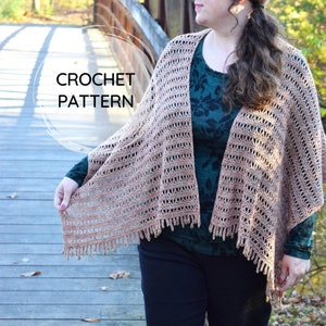 May include: A crocheted shawl with a delicate openwork pattern in a light brown color. The shawl has a fringe border with small beads. The text "CROCHET PATTERN" is visible in the image.
