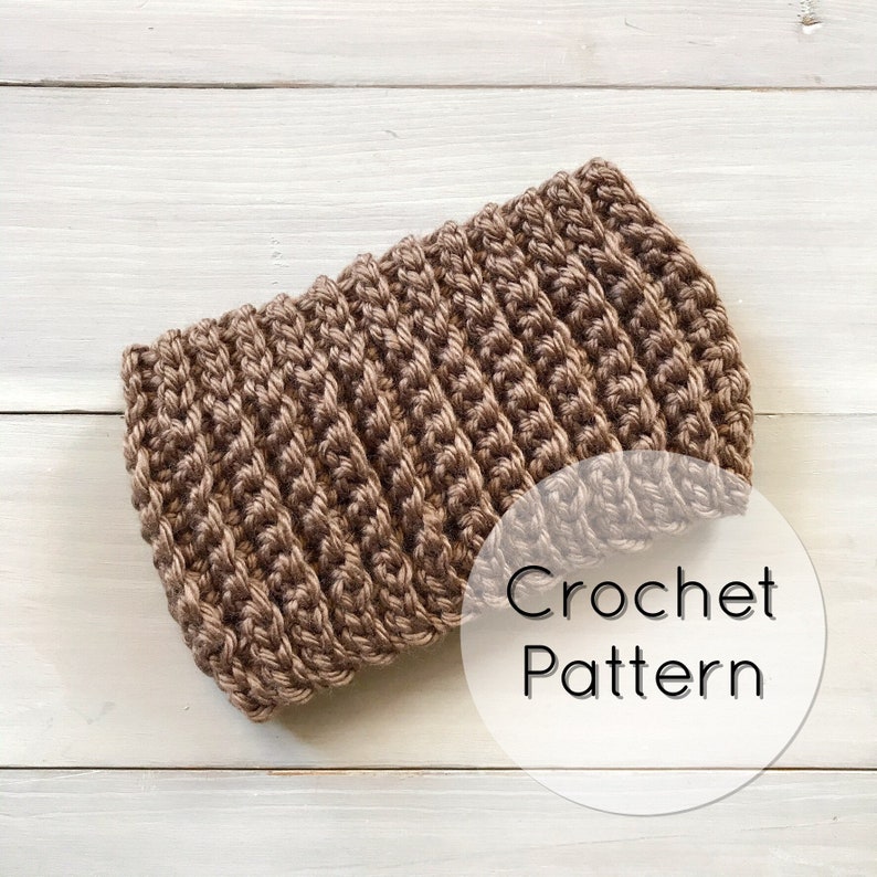 Puede incluir: Una diadema de crochet marr&oacute;n con un c&iacute;rculo blanco que dice "Crochet Pattern".