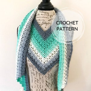May include: A crochet pattern for a triangular shawl with a green, white, and gray color gradient. The shawl is displayed on a mannequin.