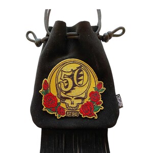 May include: Black velvet drawstring bag with a gold embroidered skull and roses design. The bag has a fringe trim and says "50" and "EST 1965".