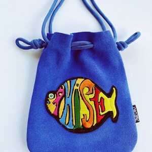 May include: A blue drawstring bag with a colorful embroidered fish design featuring the word "Pisces".