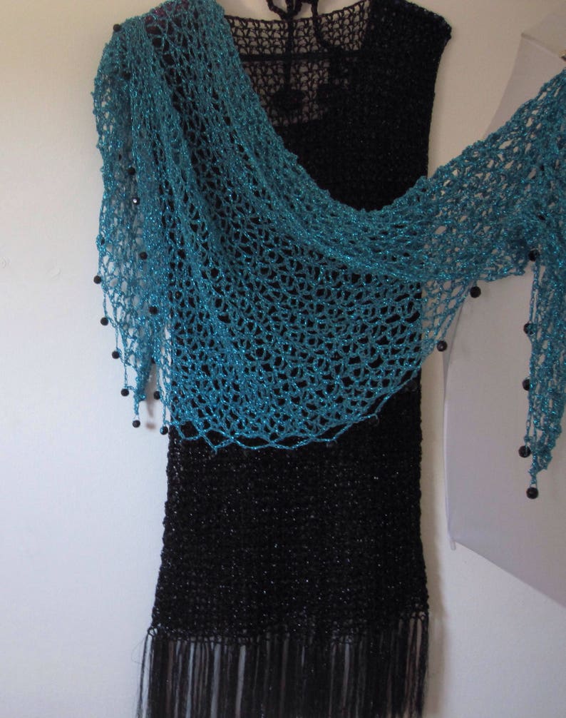 Turquoise shawl arranged side-swept on a black dress, highlighting the beaded edge and airy crochet.