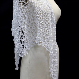 Side view of the white shawl on the mannequin, showing the openwork falling past the shoulder.