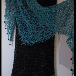Closer view of the turquoise shawl on the black dress, showing the soft cowl drape and beaded openwork.