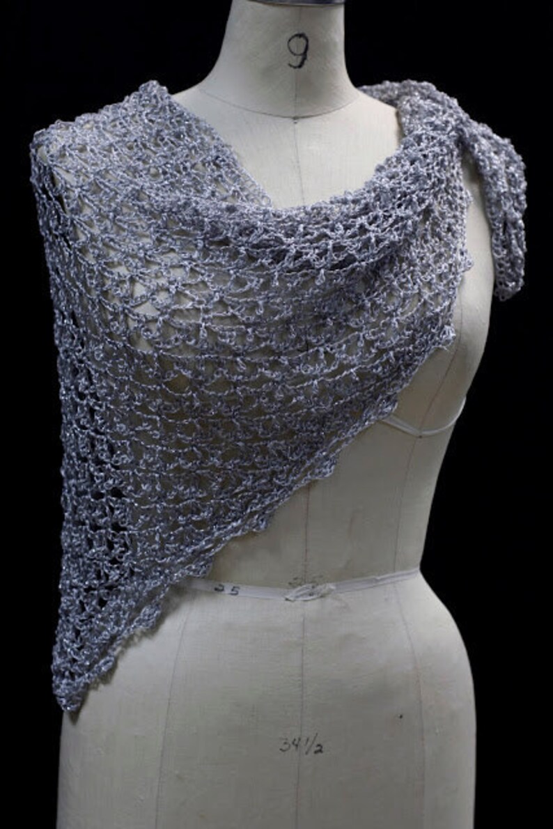 Lightweight silver-white shawl draped on a dress-form mannequin against a dark background, front three-quarter view.