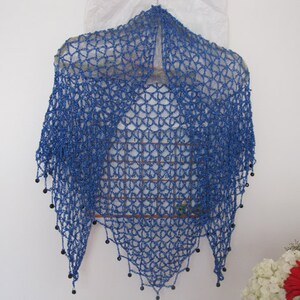 Sapphire blue shawl hanging centered, full front view of the openwork wrap.