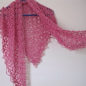 Pink shawl on a hanger with one end draped long, view of the flowing beaded trim.