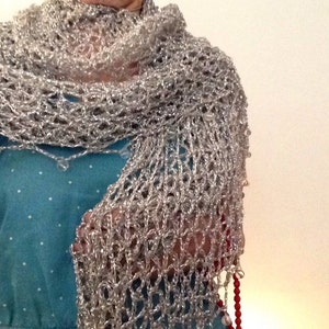 Silver lurex shawl wrapped around the neck and shoulders over a teal dress, highlighting the beaded trim along the edge.