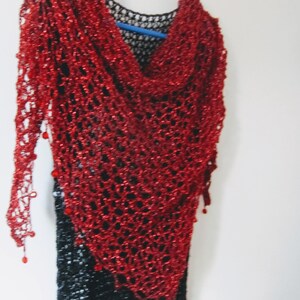 Red shawl over a black dress, closer view of the soft cowl neckline and airy crochet stitches.
