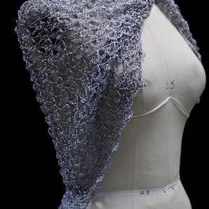 Side view of the silver-white shawl on the mannequin, draped over one shoulder.