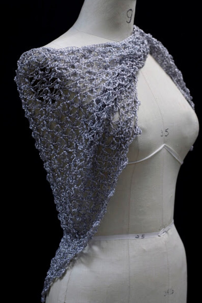 Side view of the silver-white shawl on the mannequin, draped over one shoulder.