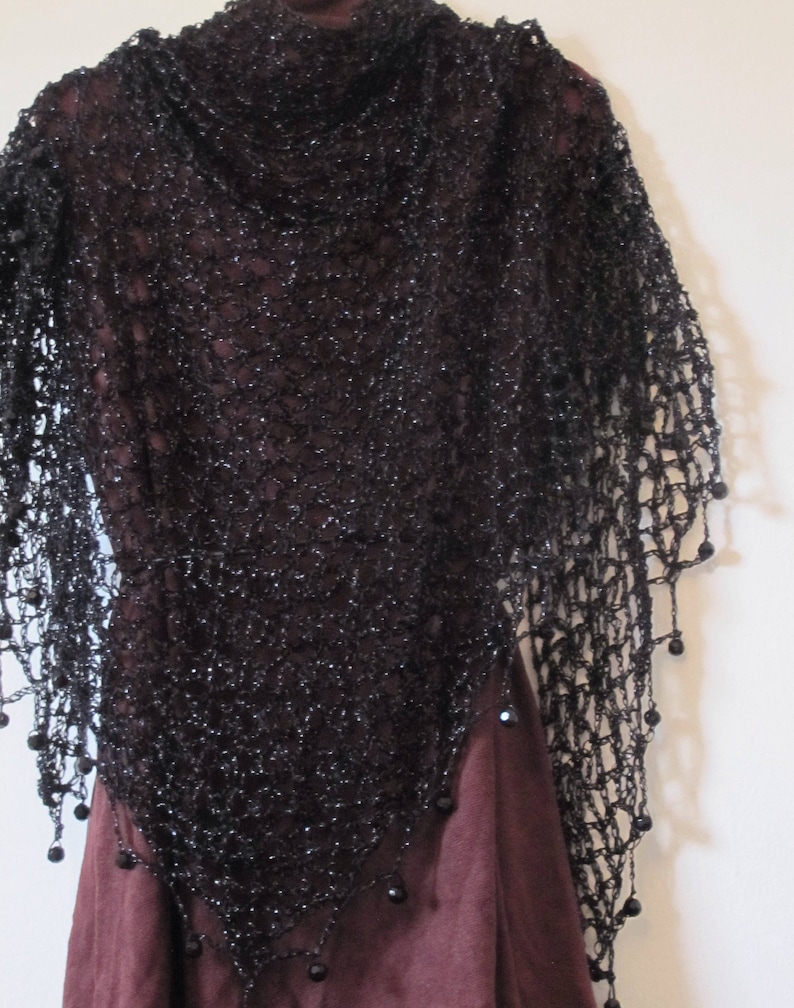 Black lurex shawl draped over a burgundy dress, front view of the sparkling wrap and beaded trim.